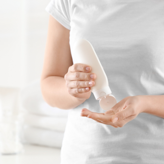 Persona aplicándose crema corporal