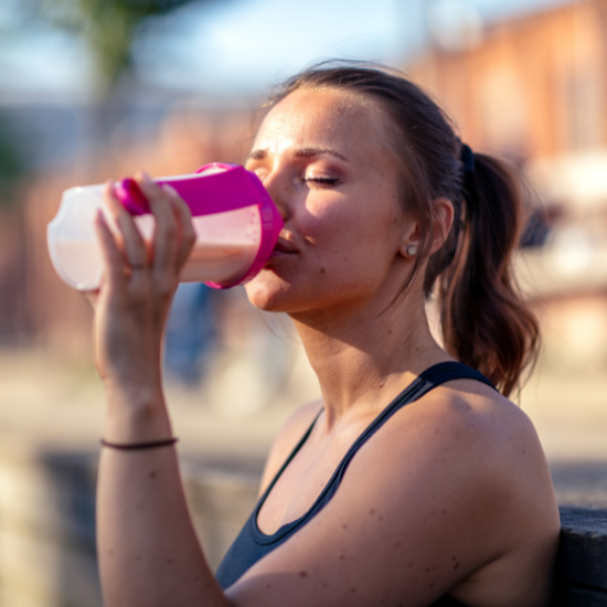 Mujer bebiendo un batido de proteínas